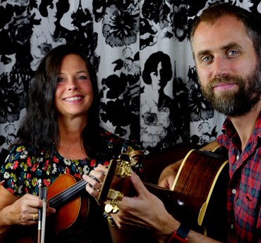 Affischbild för "Sven Bertil - En resa genom tonerna och orden". En kvinna med fiol och en man med en gitarr.
