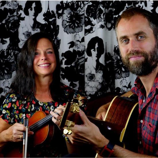 Affischbild för "Sven Bertil - En resa genom tonerna och orden". En kvinna med fiol och en man med en gitarr.